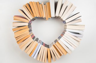 An assortment of books that have been positioned in the shape of a heart