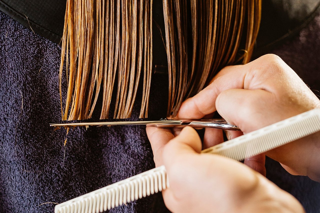 A hairdresser cutting a woman's hair