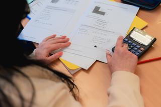 Prison learner doing maths work with a calculator beside her