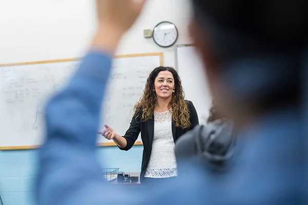 Teacher engaging with a student in a small classroom setting