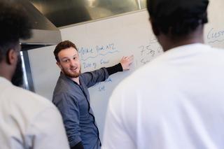 Novus teacher in front of a whiteboard