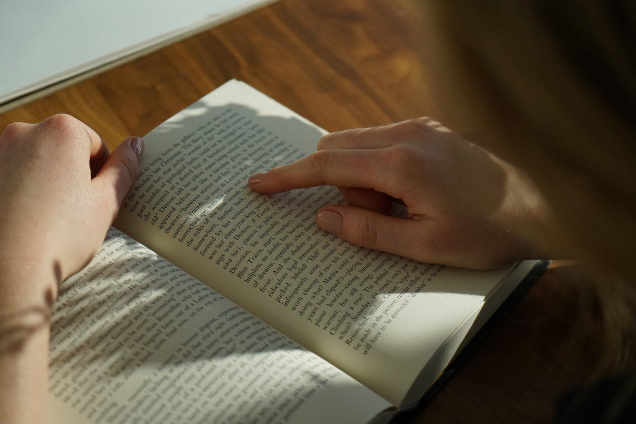 A person is seated at a desk reading