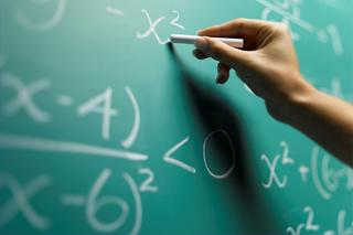 Close up of a hand writing on blackboard