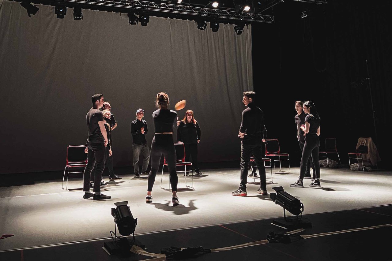 People stood on a stage, practicing drama