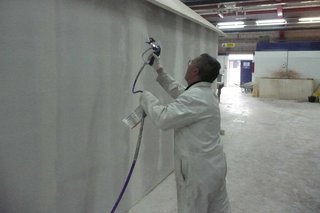 Man sprays wall with plaster