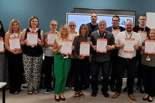 Participants from the first LEaD cohort holding certificates at the programme completion ceremony in July.