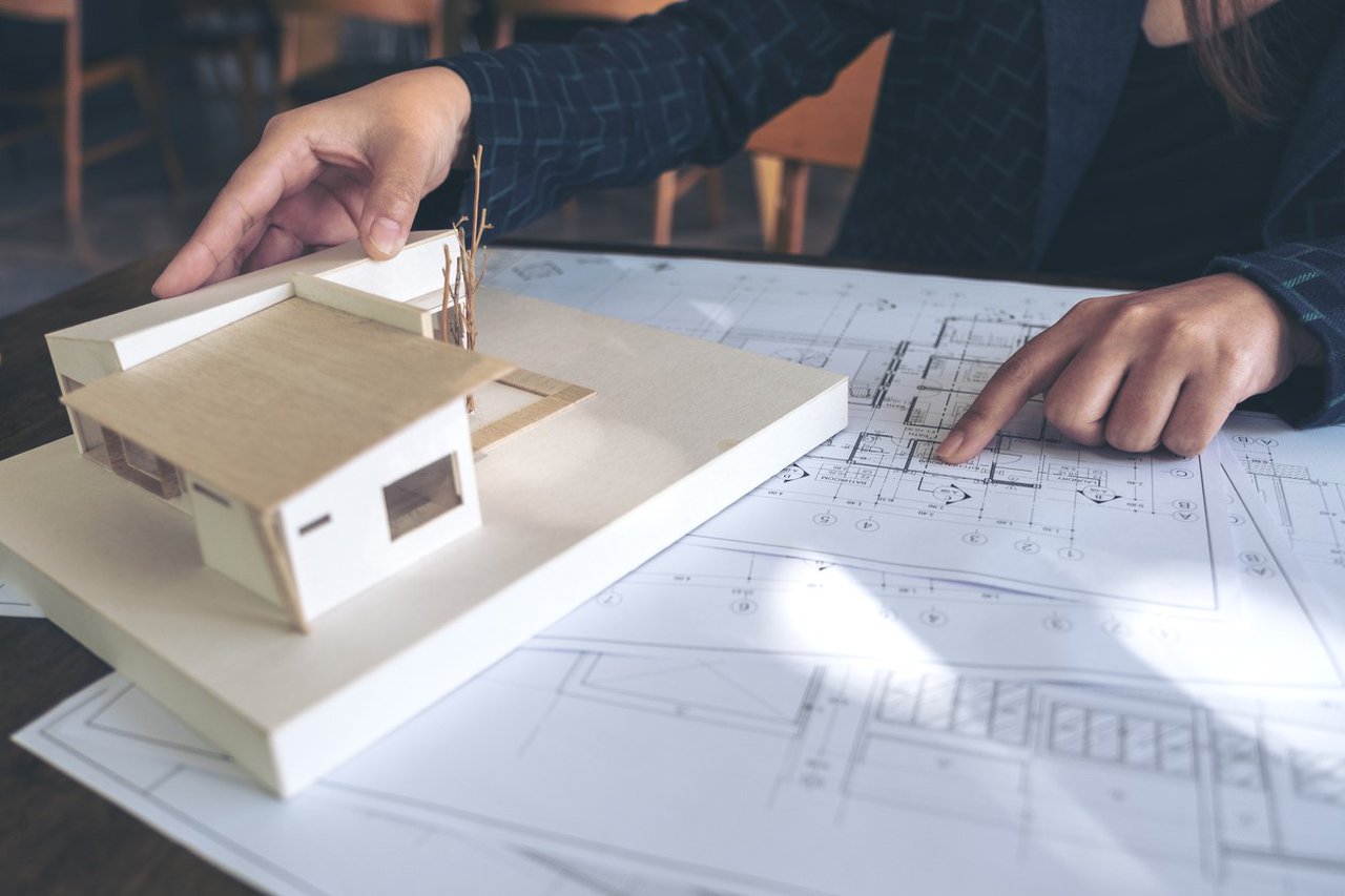 Close-up of someone creating a model house using woodwork techniques