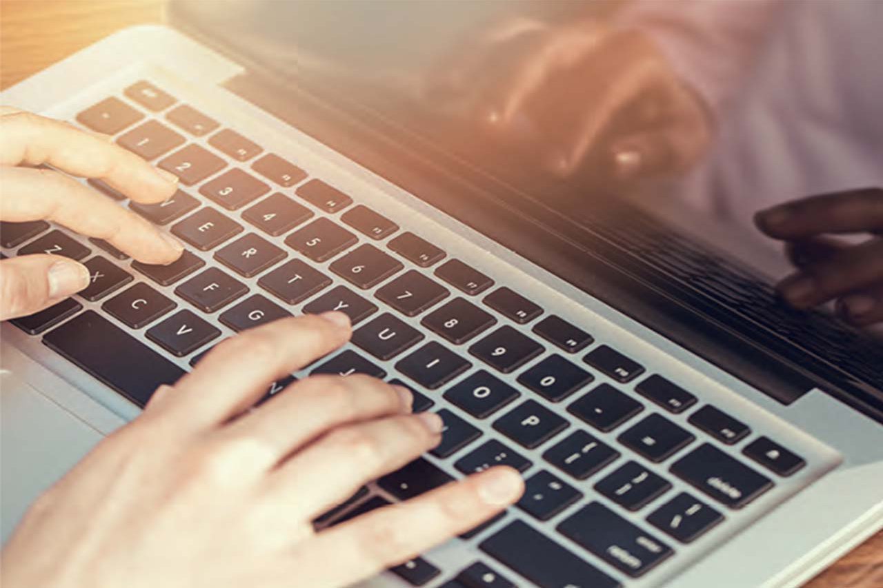 Close-up of someone typing on a laptop