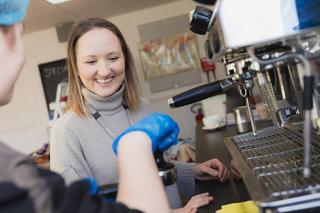 Novus colleague helping a barista learner with the coffee machine during a lesson