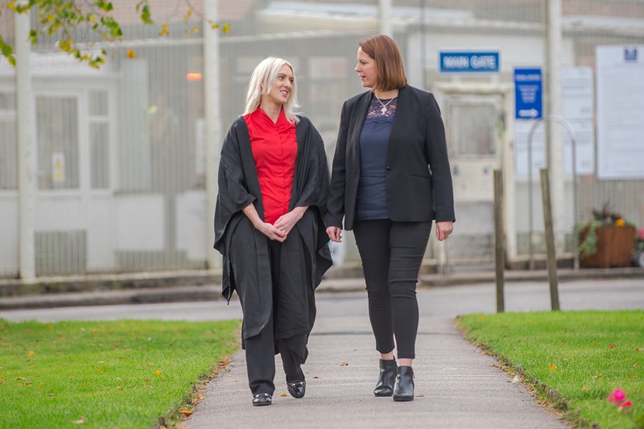 Two woman walking and talking to each other