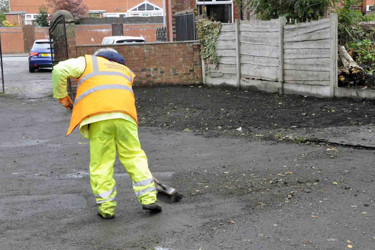 A person cleaning up an outdoor space