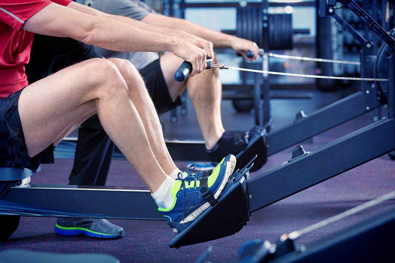 Two people sat on rowing machines