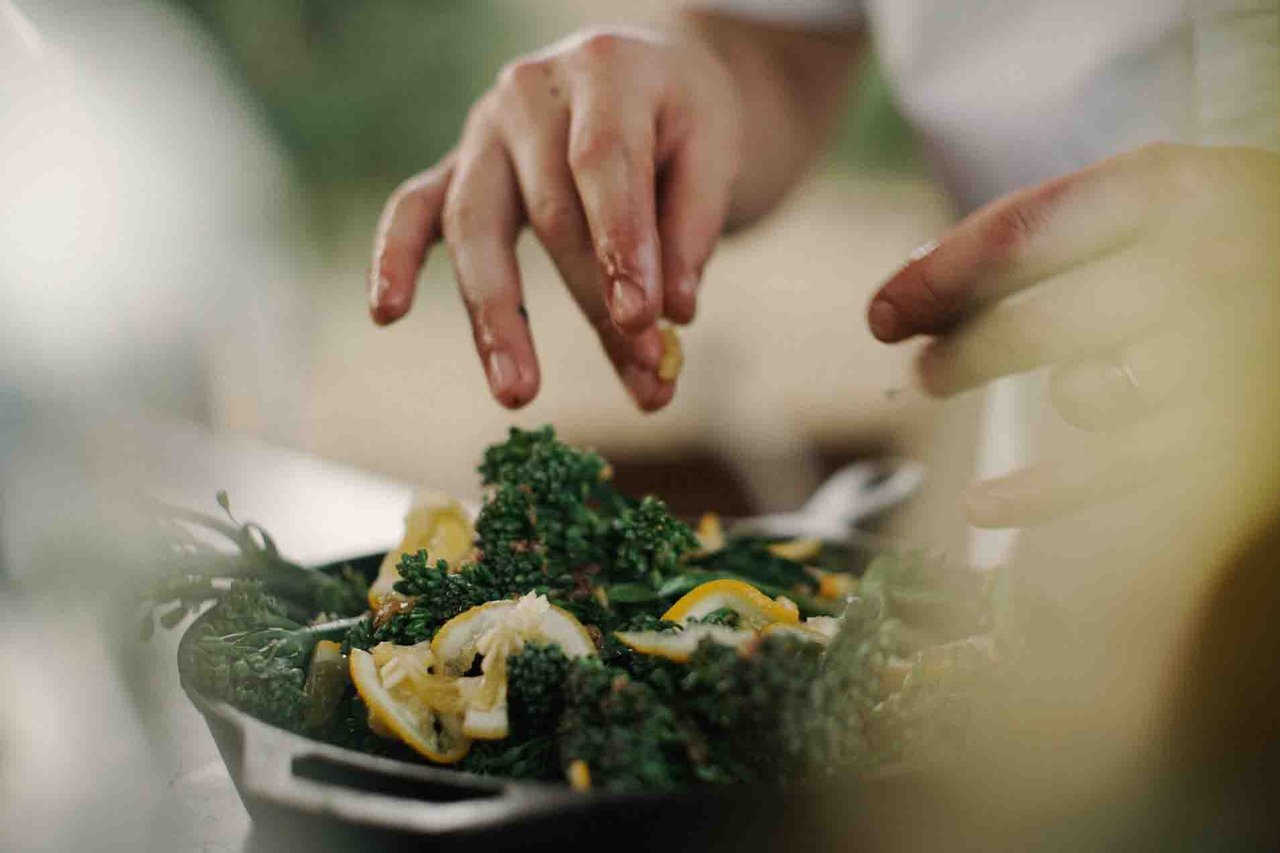 Hands garnishing a dish