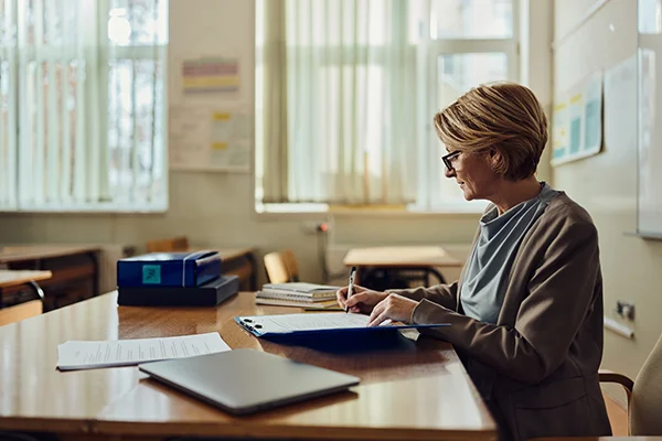 Woman working at a desk, representing the importance and variety of support roles in education and professional settings.