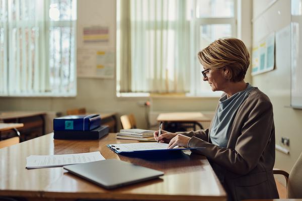 Woman working at a desk, representing the importance and variety of support roles in education and professional settings.