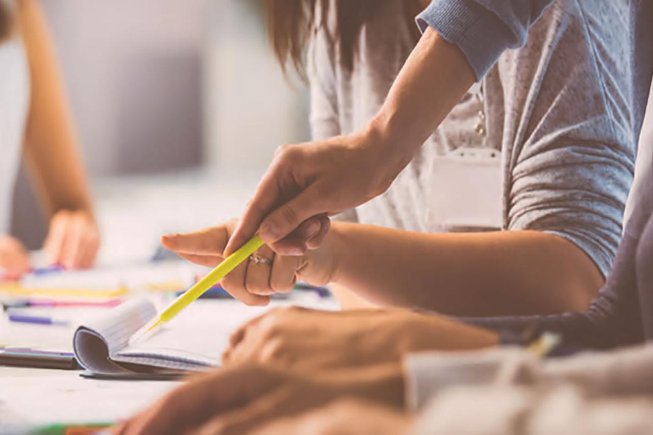 Close-up of someone writing on a pad of paper