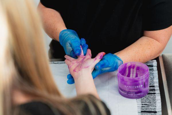 Learner rubbing manicure scrub on someone's hand