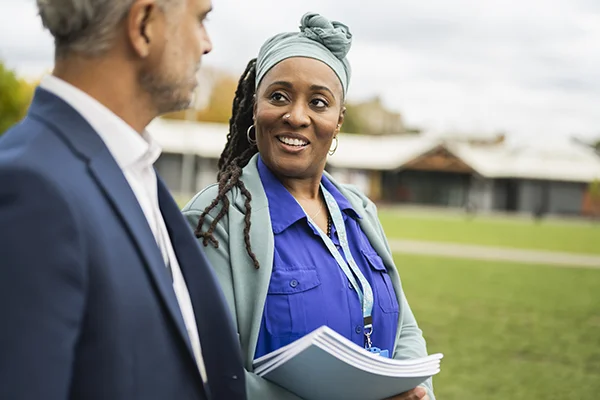 Two people talking in a friendly manner, highlighting teamwork and a supportive collaborative environment.
