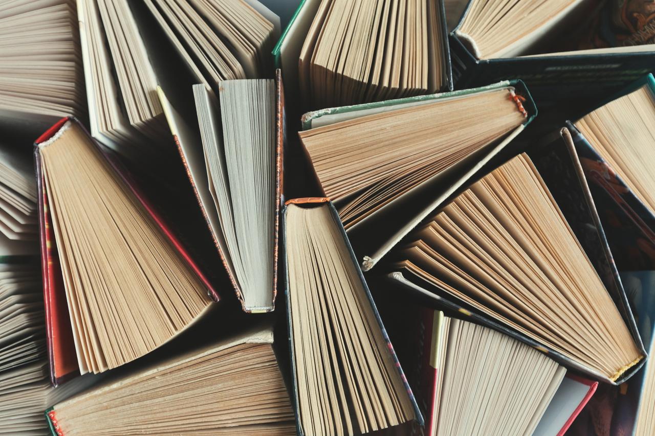 A selection of books, partially open, stood up and photographed to show the book pages