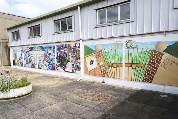 Exterior of a prison education building featuring artwork created by young learners with Novus.