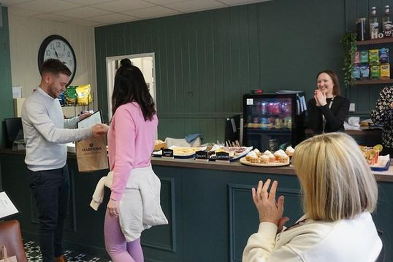 Novus learner shaking hands to celebrate graduation, in the marston's training kitchen at HMP Styal