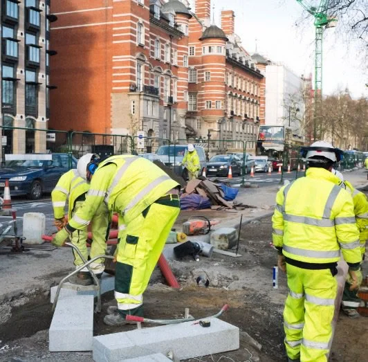 A group of workers woking on pedestrian pavement