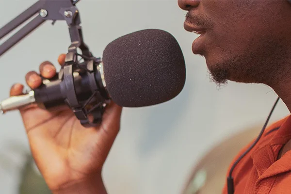 Close-up of a person speaking into a microphone during a Novus podcast recording.