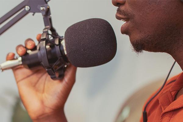 Close-up of a person speaking into a microphone during a Novus podcast recording.