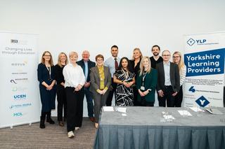 Group of people at event standing by a sign that reads Yorkshire Learning Providers