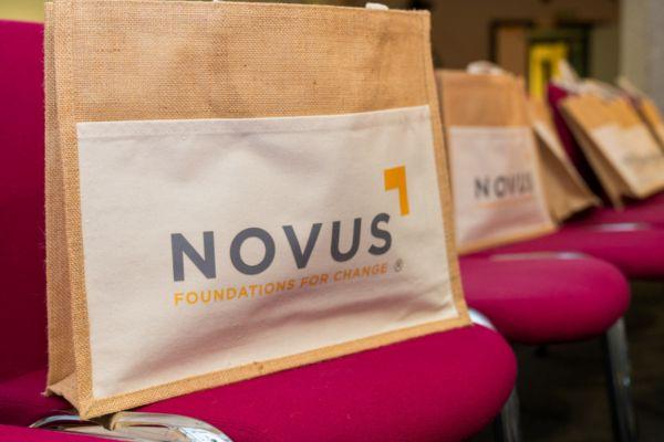 Bags with the Novus logo and tagline placed on chairs