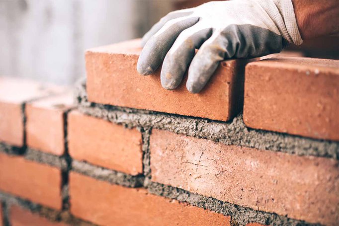 Close-up of a builder creating a brick wall