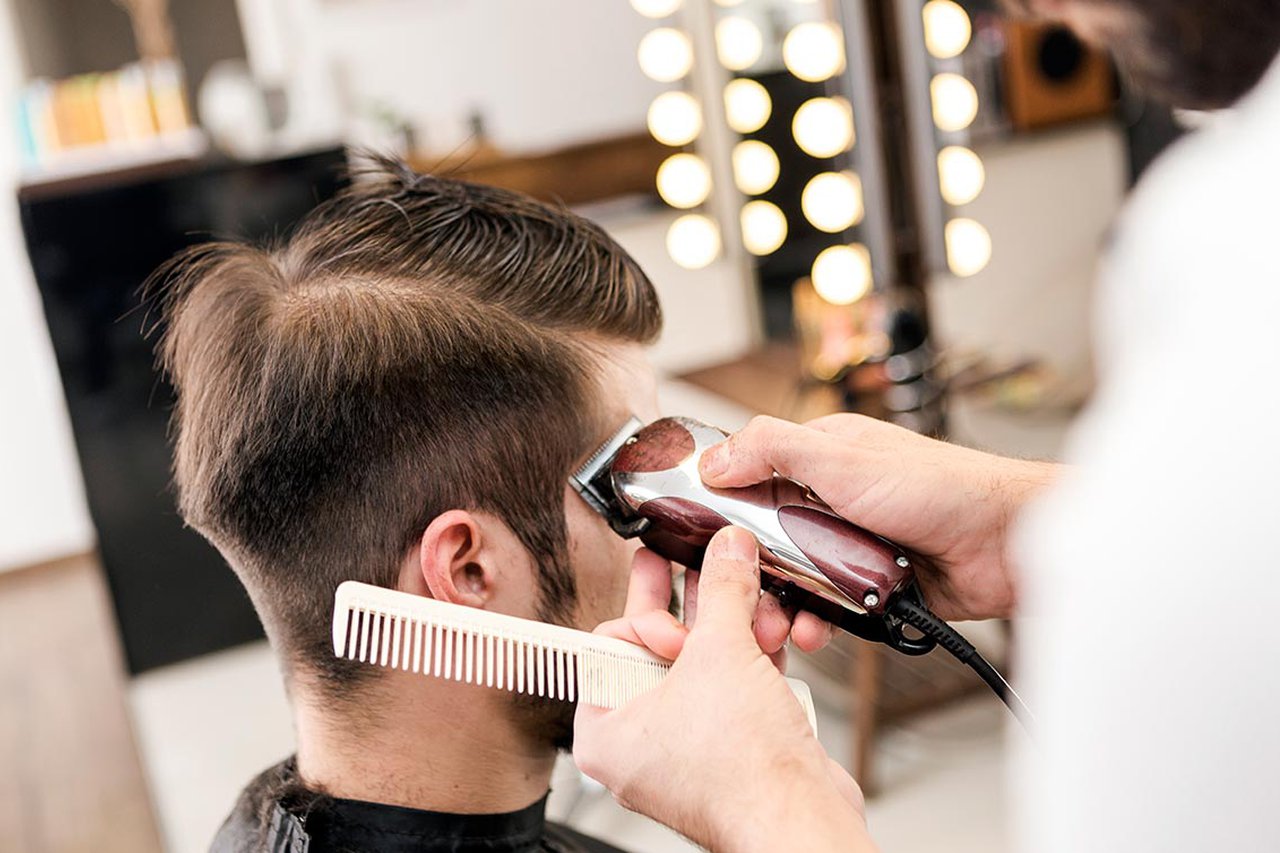 A barber cutting a mans hair