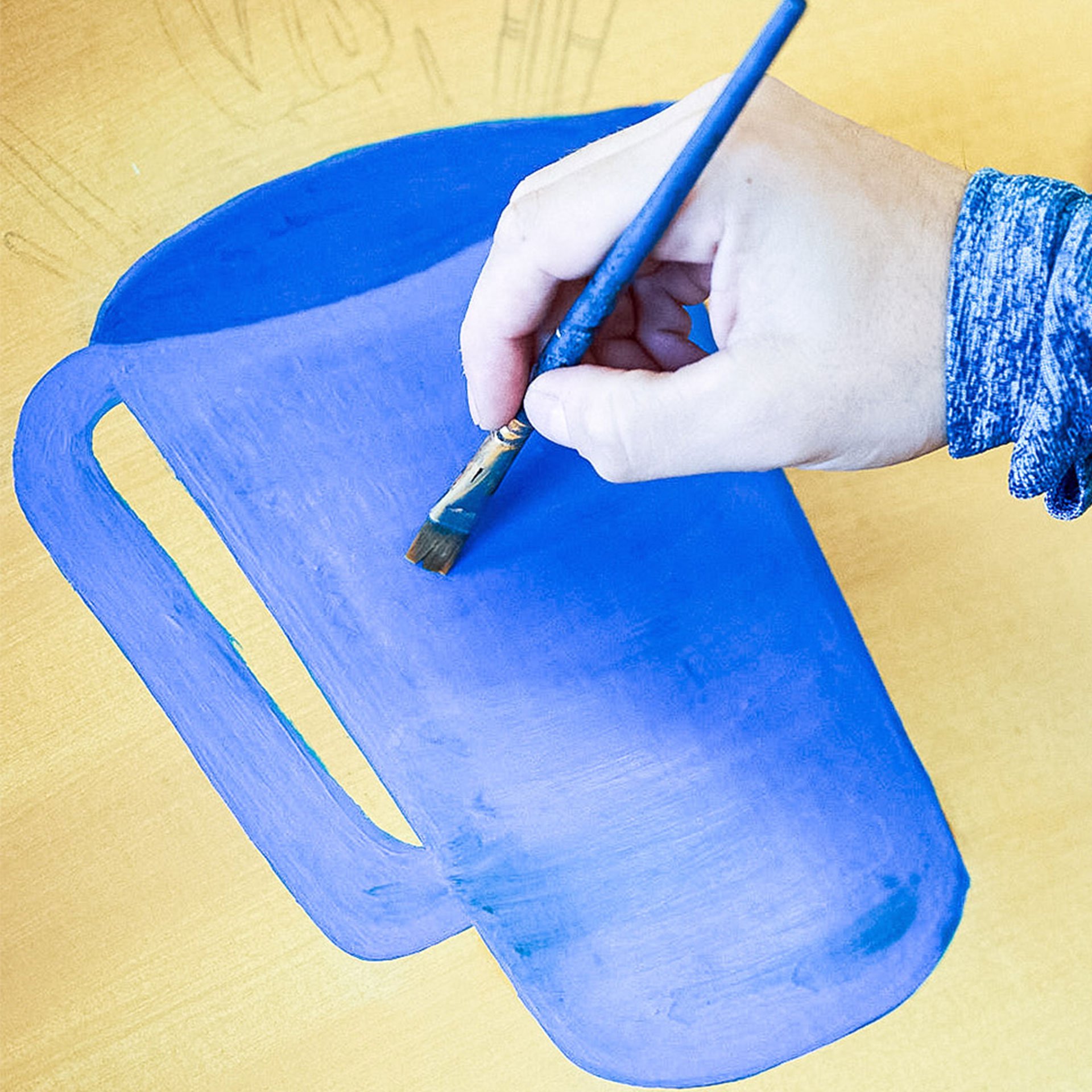 Close-up of someone painting a jug