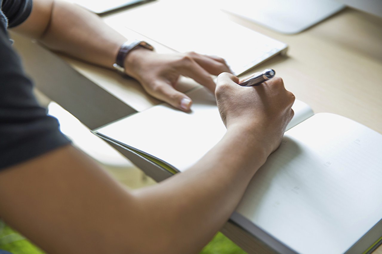 Over-the-shoulder view of someone writing