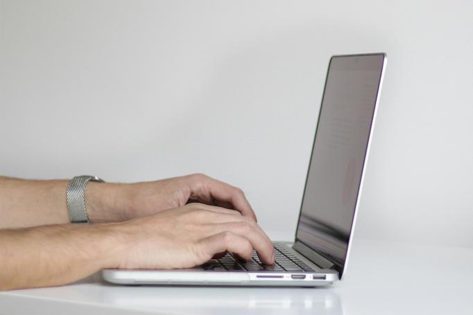 Close-up of hands typing on a laptop