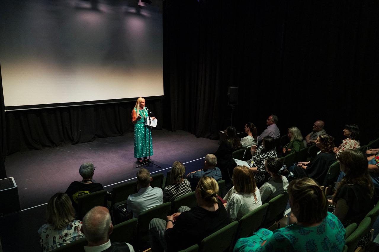 Annick Platt from Novus standing in front of an audience at Shakespeare North