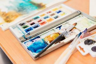 Close up of paintbrushes and a palette of watercolours in a Novus classroom