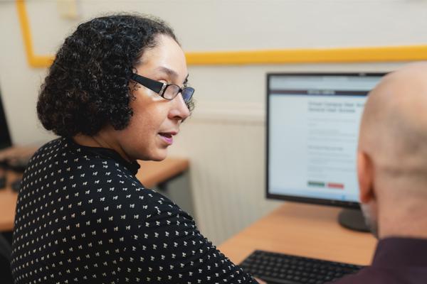 Novus tutor providing one-to-one support to an adult learner in a classroom setting.