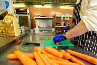Person chopping carrots in Liverpool kitchen
