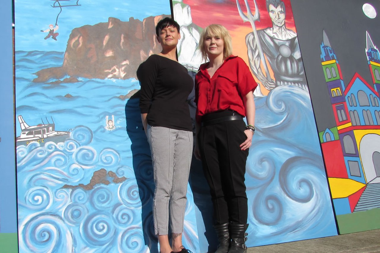Alex and Rachel stood infront of the murals they created