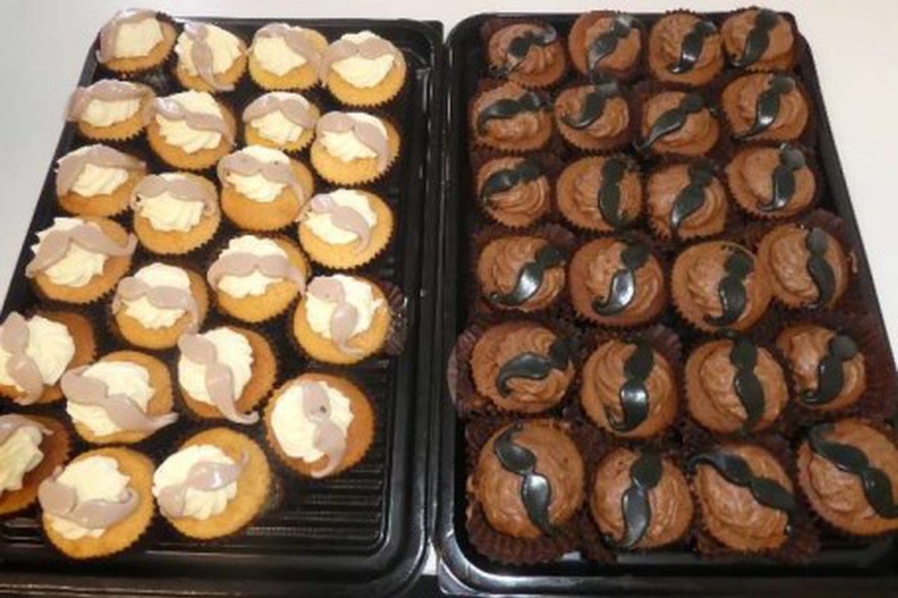 A batch of cupcakes with mustache icing