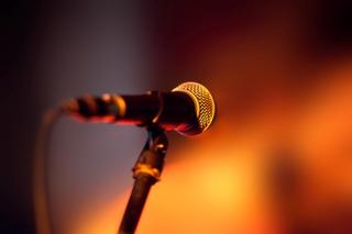 Close up of a microphone with orange lighting in the background